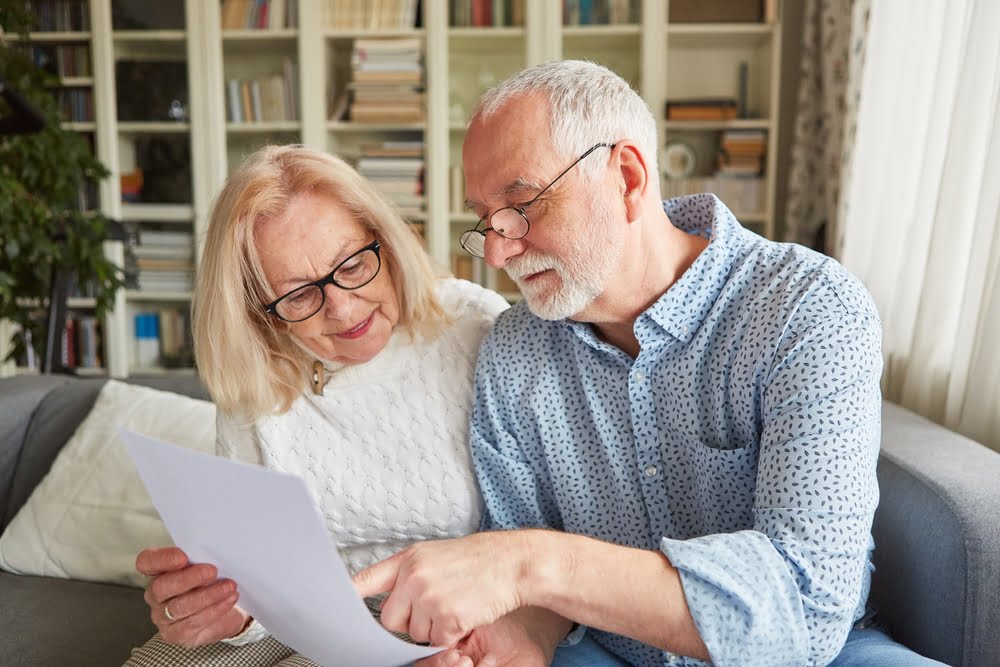 senior couple reading a retirement plan or power of attorney or living will