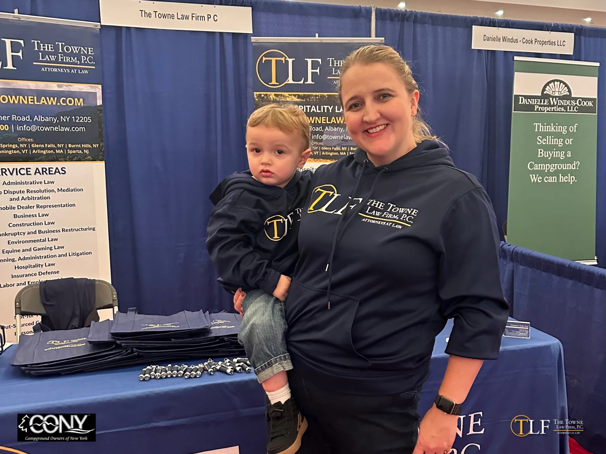 Partner Christine Taylor and her toddler posing at trade show booth