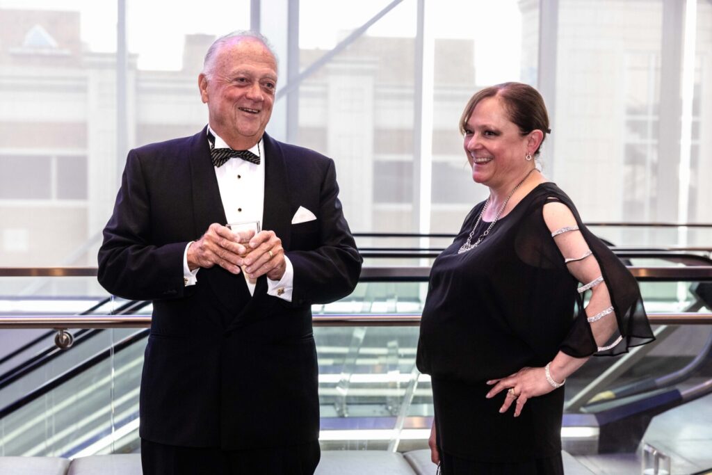People smiling and talking at an event.